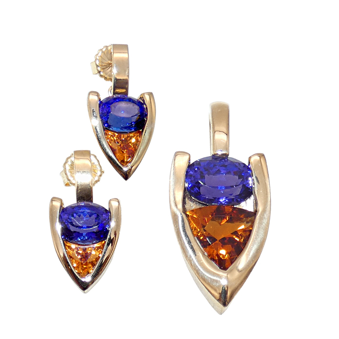 Item# CCJ-KPY-TZ-C-2441 – Pendant Item# CCJ-KEY-TZ-SG-2459 – Earrings Designer: Grace Koorey Stone Cutter: Stephen Avery Pendant Stones: Oval Tanzanite = 4.21 cts, Trillion Citrine = 3.7 cts Earring Stones: Oval Tanzanite = 7.52 ctw, Trillion Spessarite Garnet = 4.05 ctw Metal Pendant: 18KYG = 9.58 dwt Metal Earrings: 18KYG = 11.7 dwt Designer Remarks: The colors of sunset in blue greets us warmly in Arrows Embrace; pendant and earring combination.